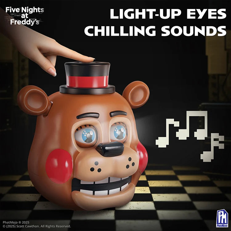 Five Nights at Freddy's Freddy the Bear light-up eyes and chilling sounds toy, featuring a brown bear head with blue eyes, red cheeks, a black top hat with a red band, and a hand touching its forehead, set against a dark checkered floor with pixelated music notes.