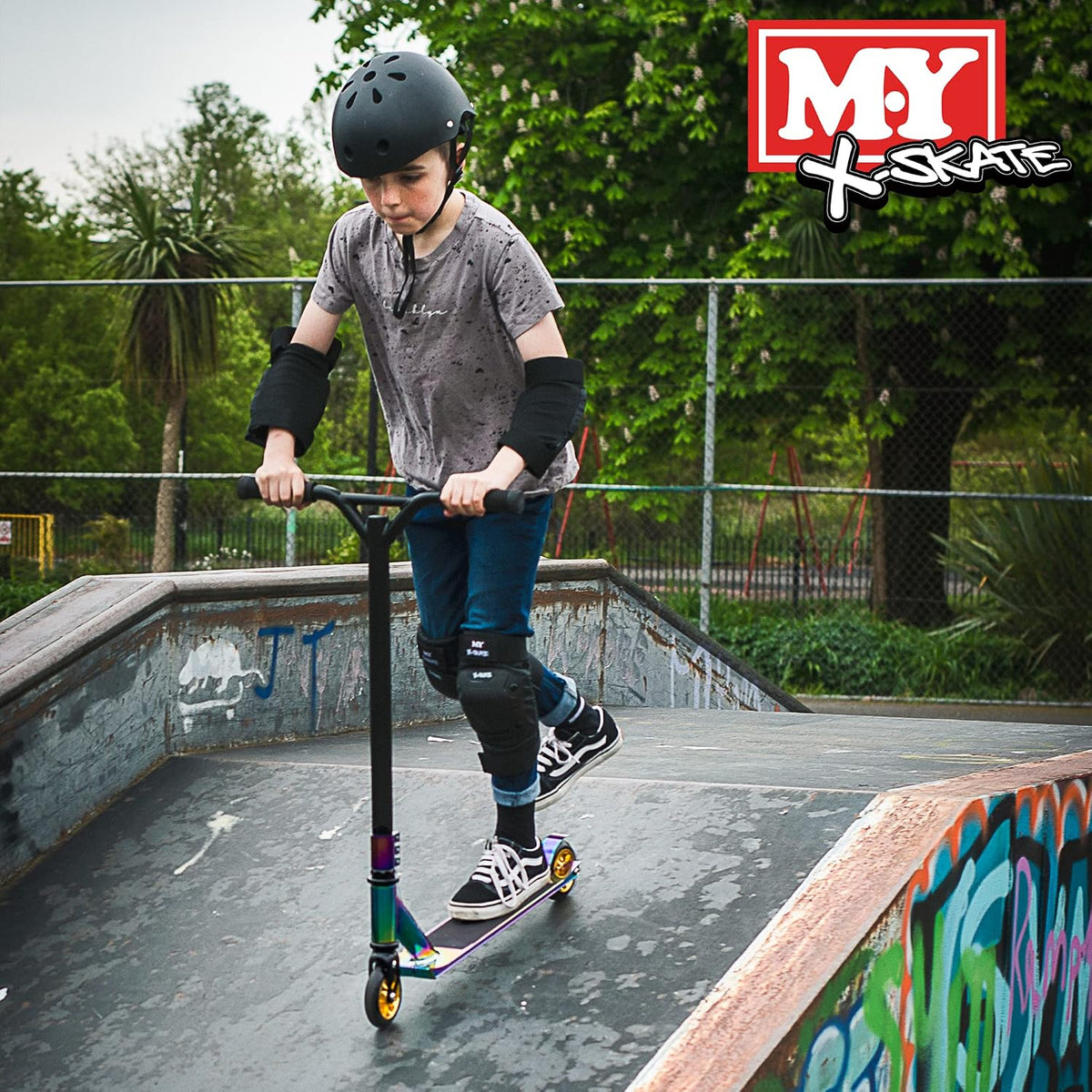 Skater on scooter at a skate park, going down a ramp