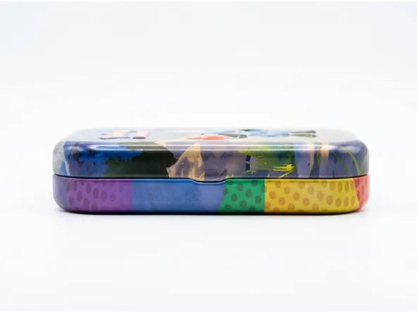 A rectangular metal pencil case with rounded corners, featuring a colorful abstract pattern on the top half and a striped pattern of purple, blue, green, and yellow polka dots on the bottom half, set against a plain white background.